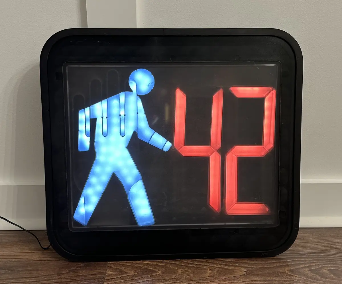 Pedestrian crossing light showing a walk signal and the number 42.